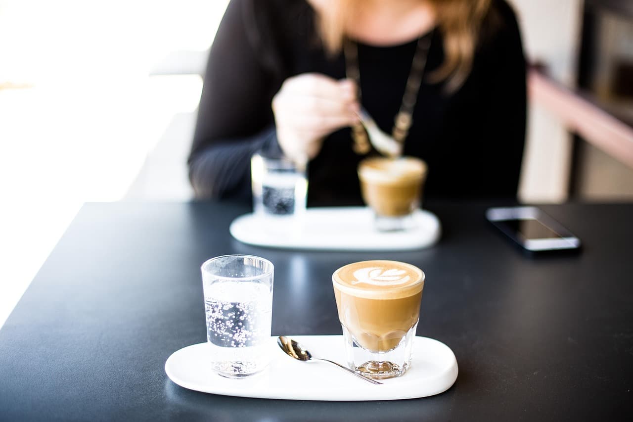 Two cortados on a dark cafe table