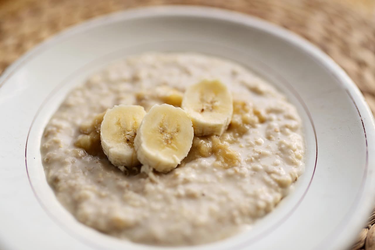 A bowl of creamy porridge topped with sliced banana